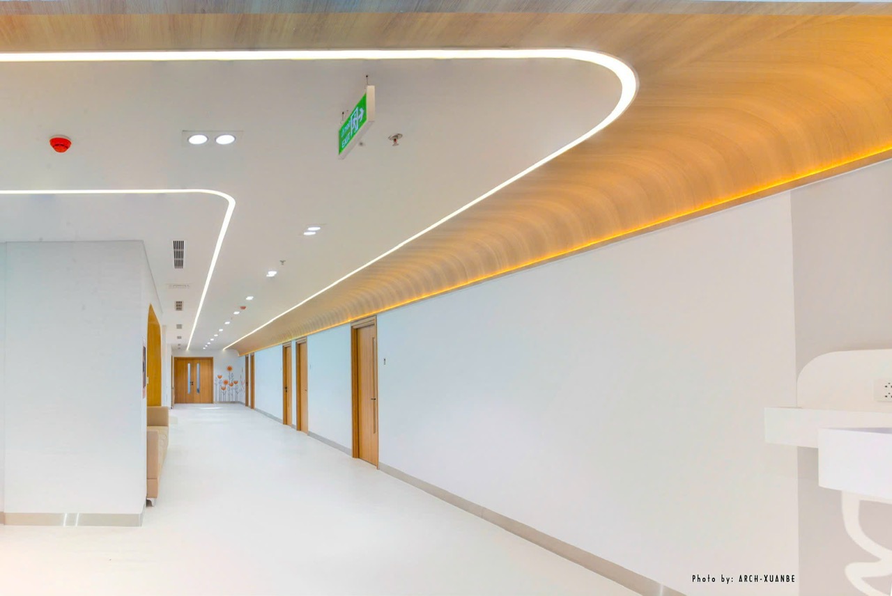 Hospital corridor ceiling in plasterboard combined with curved laminate panels