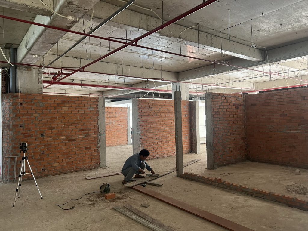 Building partition walls in a factory office, set out with a laser level, fire sprinkler pipes overhead